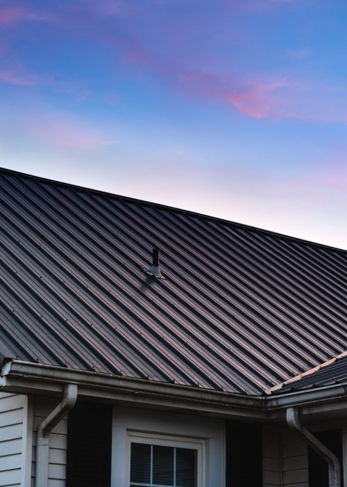 A vertical shot of a beautiful house metal roof during the sunset