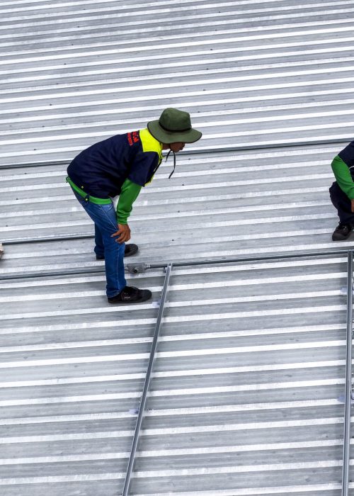 Professionals working on solar panel setup on an industrial rooftop, promoting clean energy solutions, efficiency, and the commitment to renewable energy in urban development.