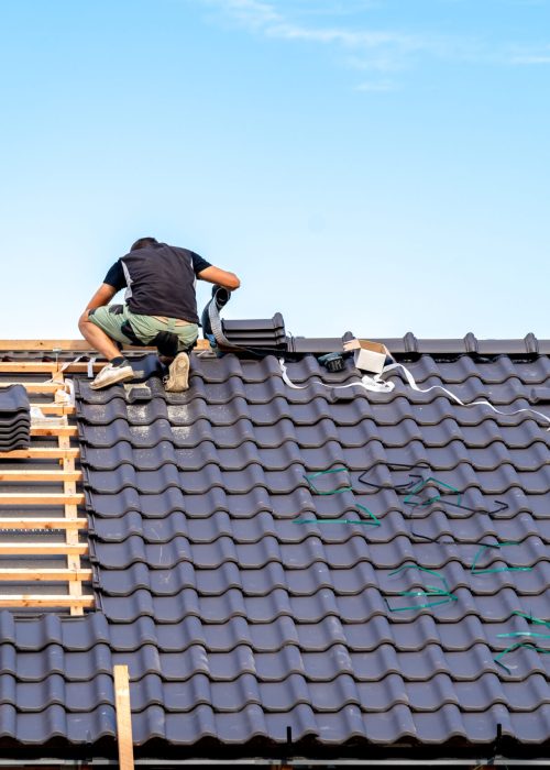 craftsman builds a new roof from ceramic tiles.